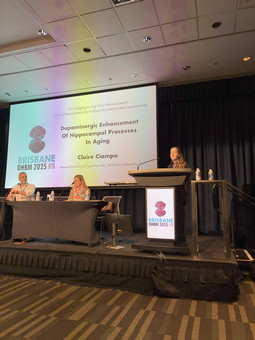 Cliare standing at the podium giving a talk at OHBM